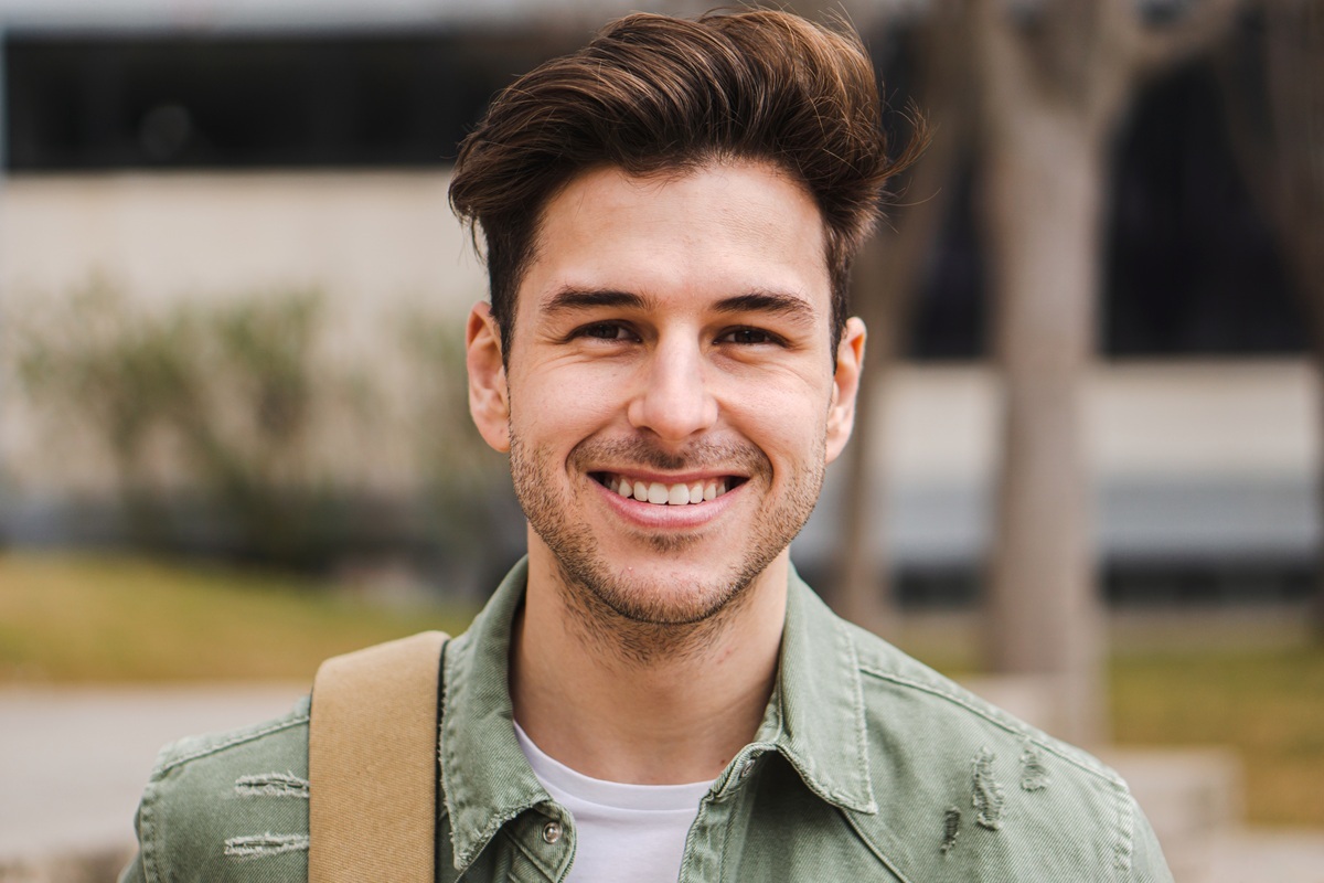 Smiling man in casual attire representing busy professionals seeking convenient dental care solutions.